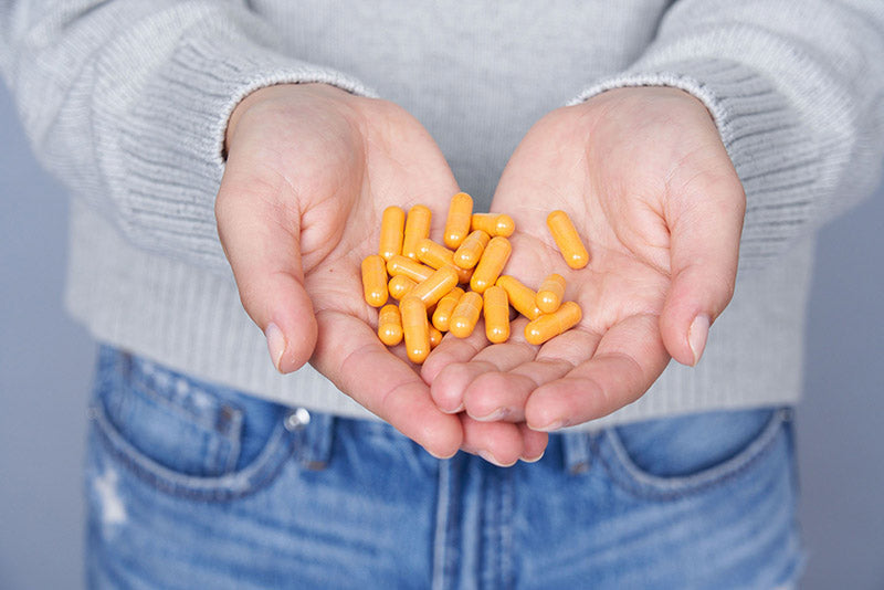 Turmeric capsules in hand